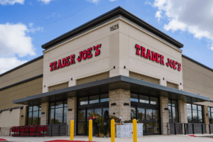 Exterior of the new Trader Joes Broken Arrow store showing the storefront, red signage, and entrance on a bright day.