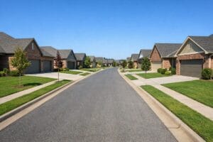 Residential street view of Battle Creek Park Broken Arrow OK featuring single-story brick homes with sidewalks and concrete driveways