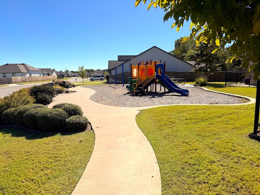 Neighborhood playground with walking paths and landscaped green space in Bixby Oklahoma subdivision.