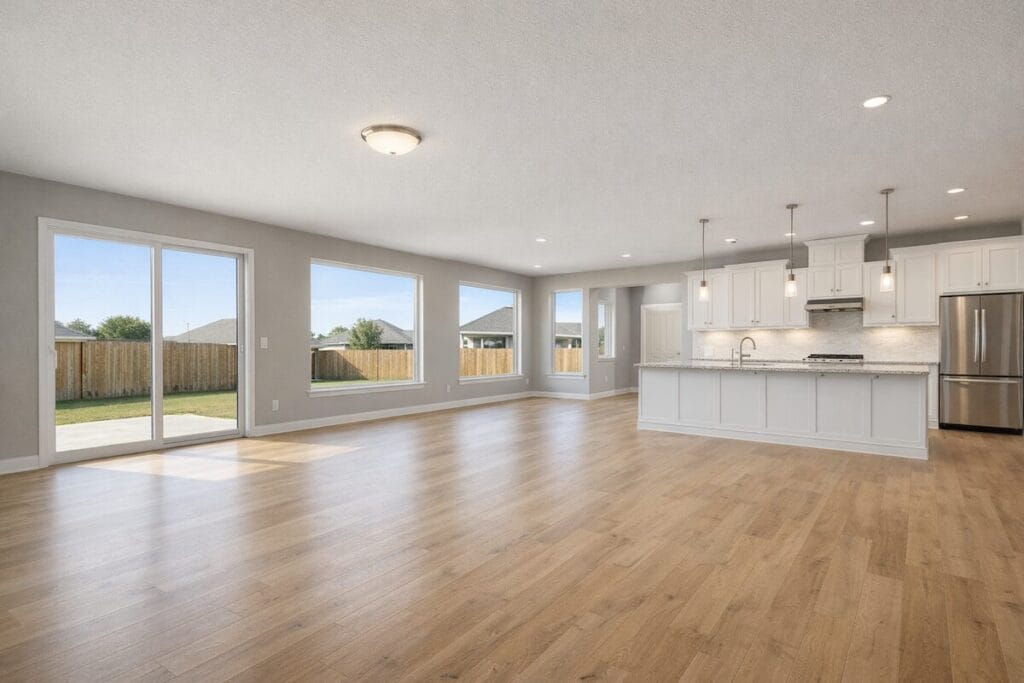 Empty living room in new construction Tulsa home showing bare windows without blinds or treatments